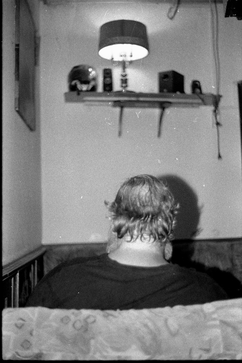 Schwarz-Weiß-Aufnahme einer Person von hinten unter einer Lampe, fotografiert mit der Porst C-TL
