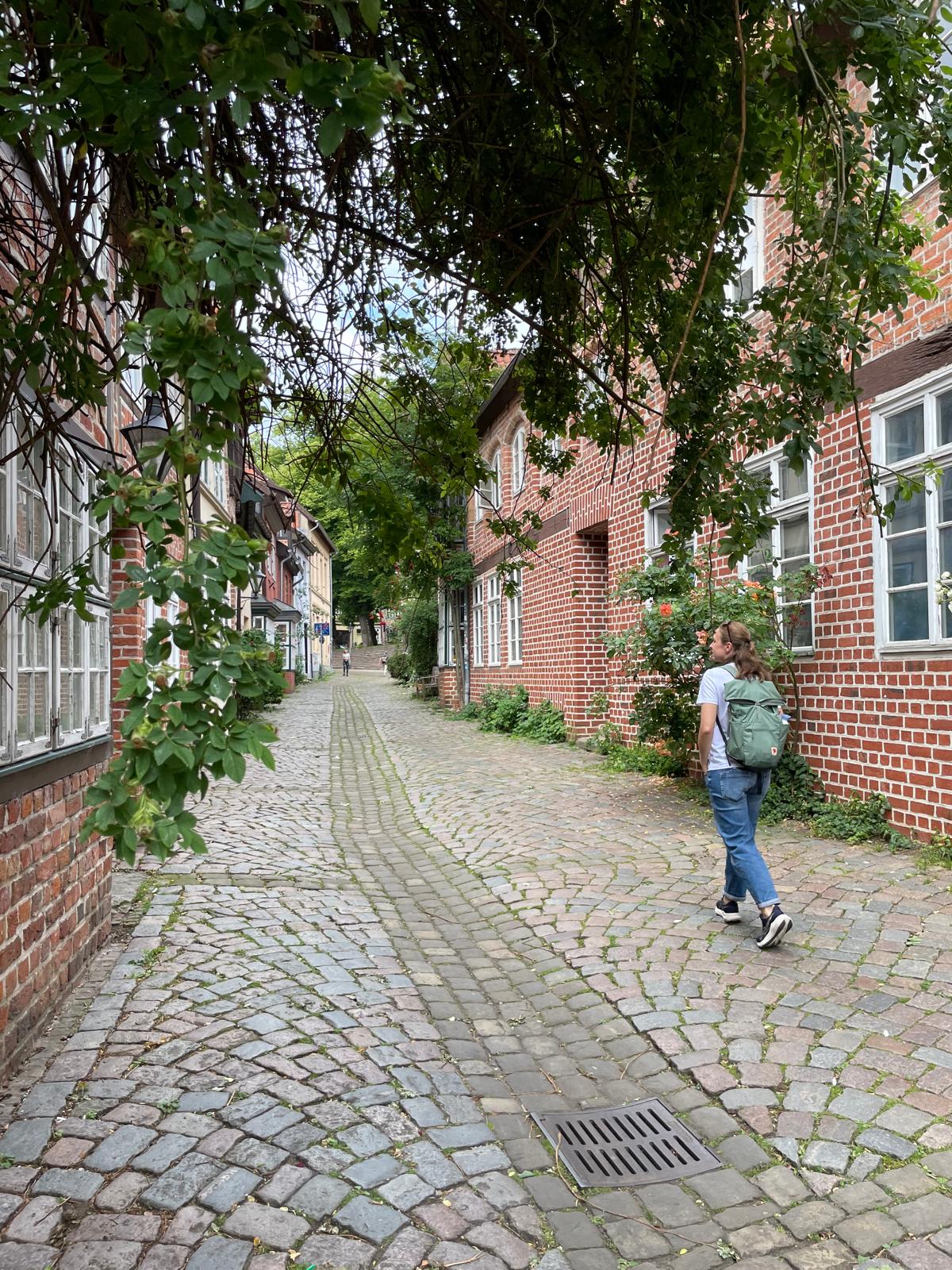 Teilnehmerin geht mit Kamera durch eine Lüneburger Gasse