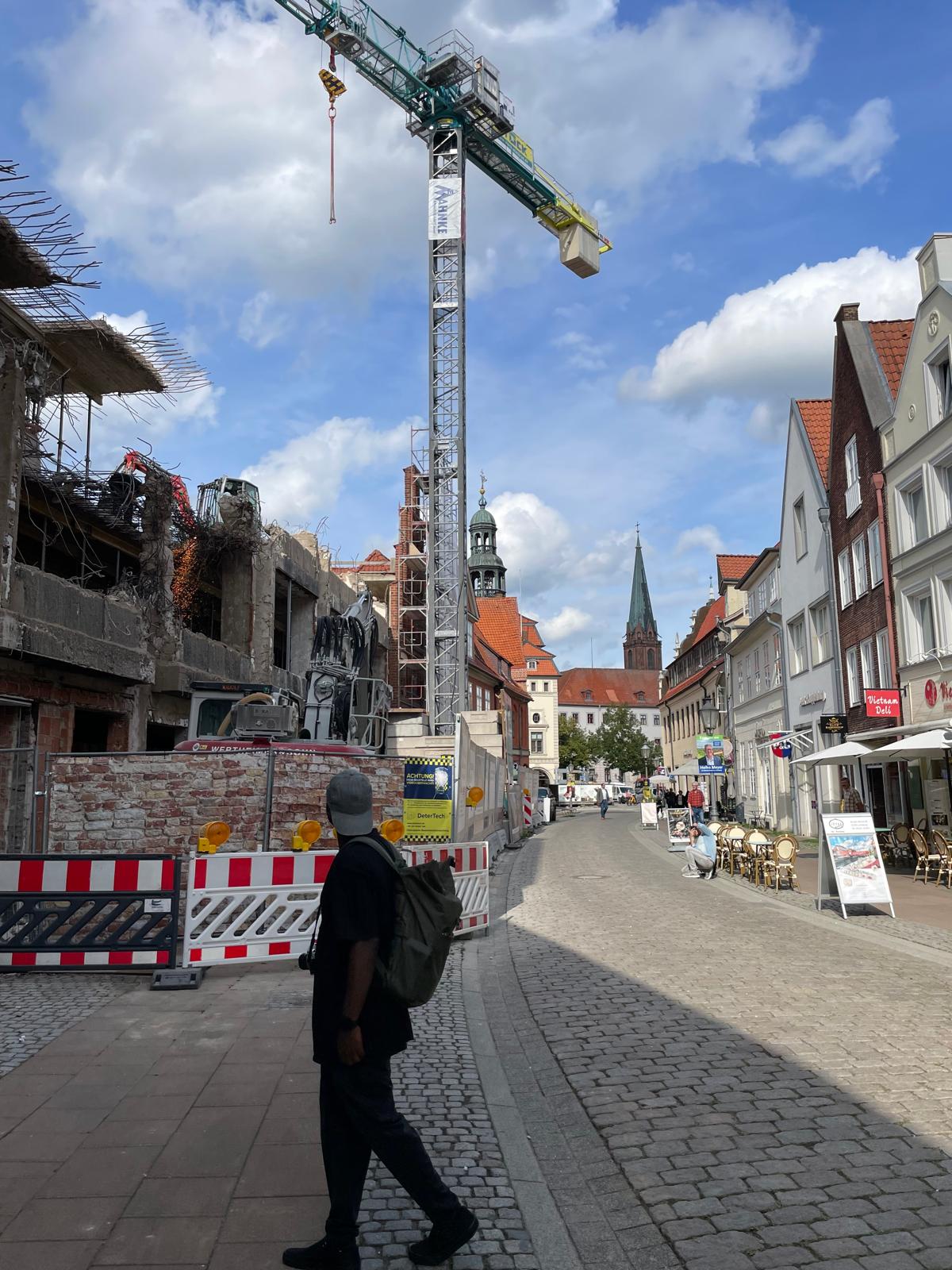 Workshopteilnehmer mit Rucksack vor einer Baustelle in Lüneburg