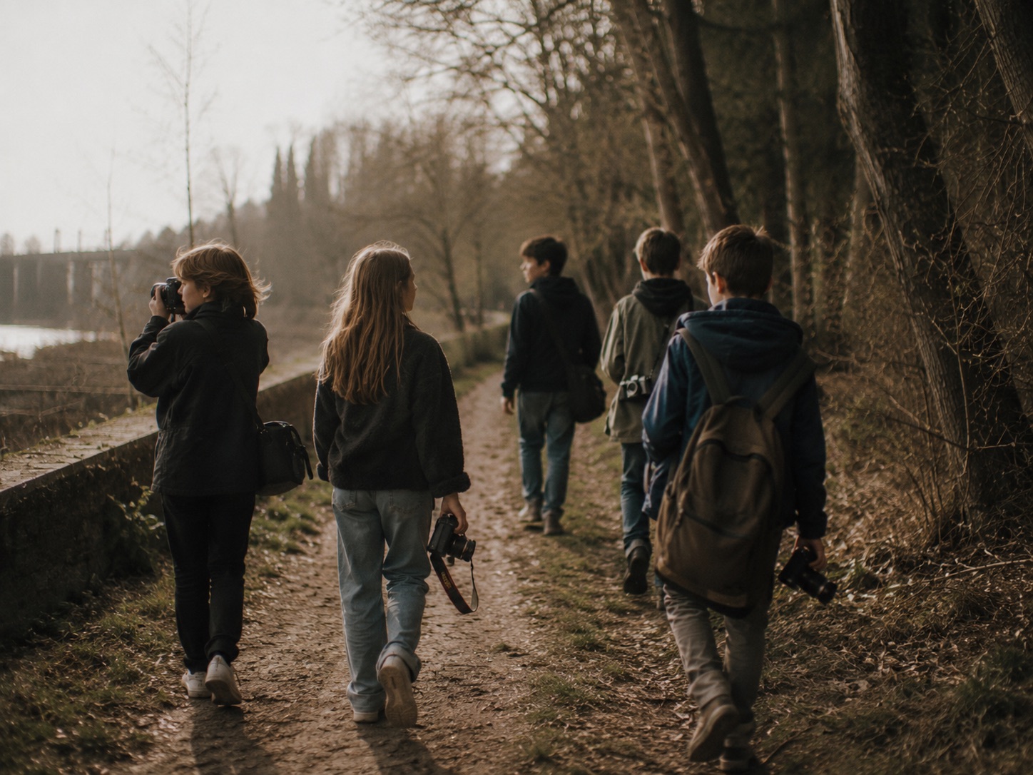 Kinder und Jugendliche gehen mit Kameras bei einem analogen Ferienkurs nach draußen