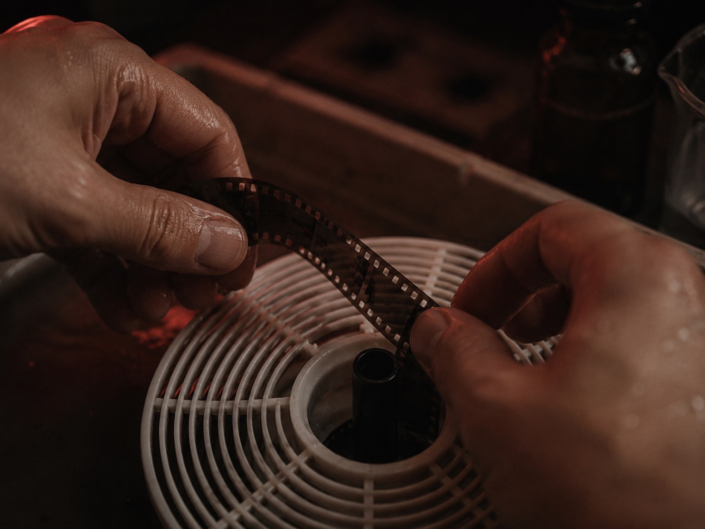 35mm-Film wird vorsichtig in eine Entwicklungsspirale eingefädelt